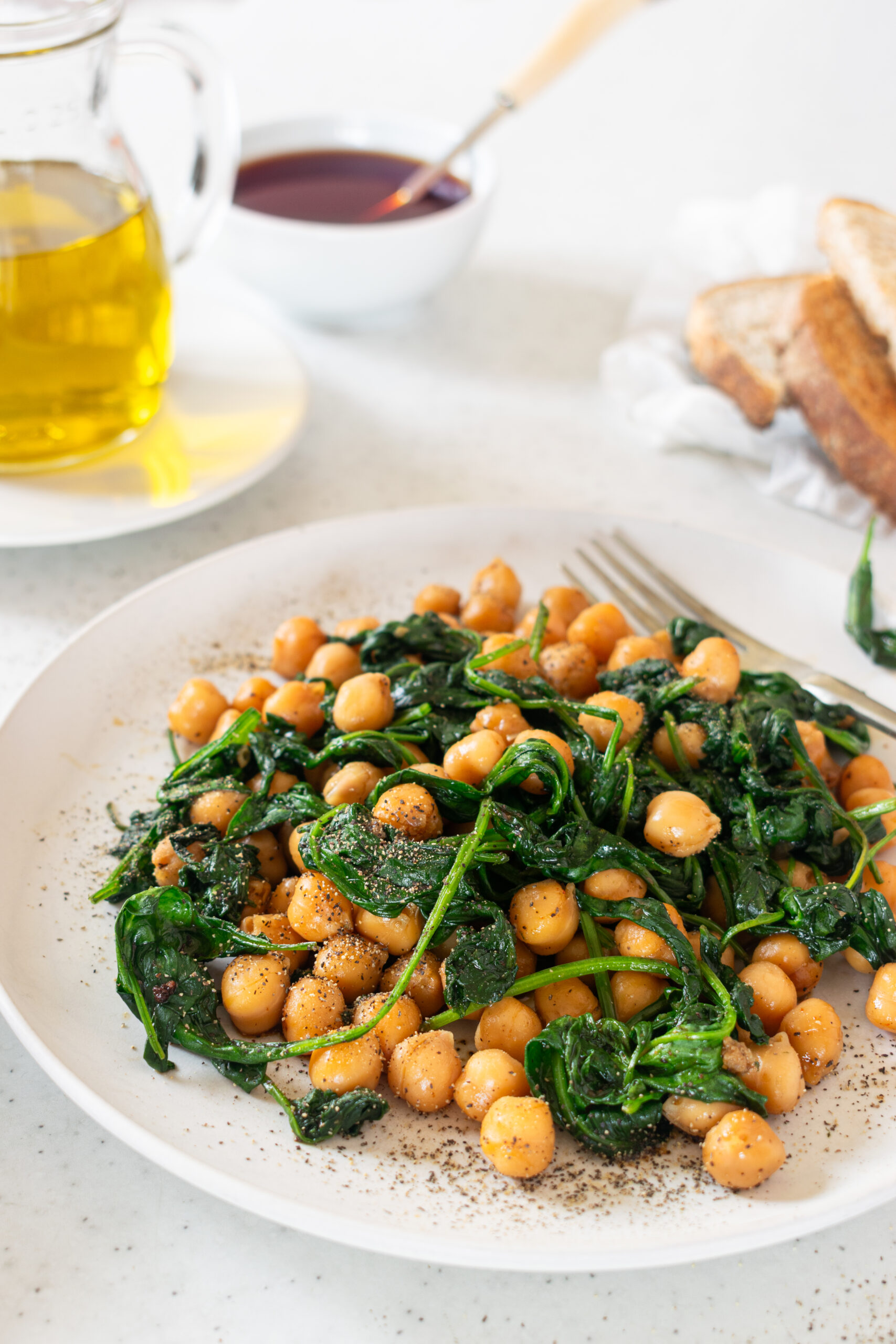 Plate of Espinacas con Garbanzos, a Spanish dish of chickpeas sautéed with spinach, seasoned with paprika, and drizzled with olive oil.